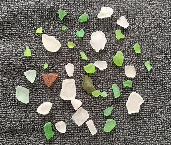 Various colors of sea glass pieces spread on a towel 