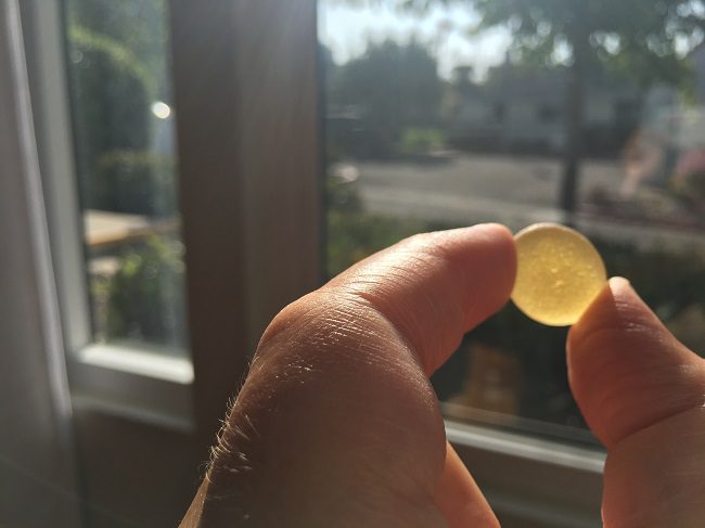 yellow sea glass in front of window from my personal sea glass collection