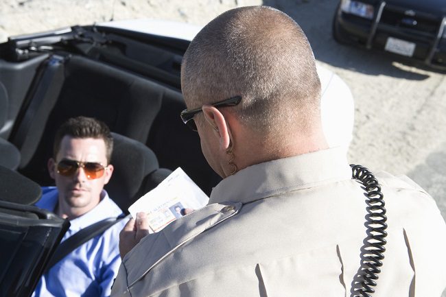 police officer stopping man in convertible for speeding while driving in San Diego 