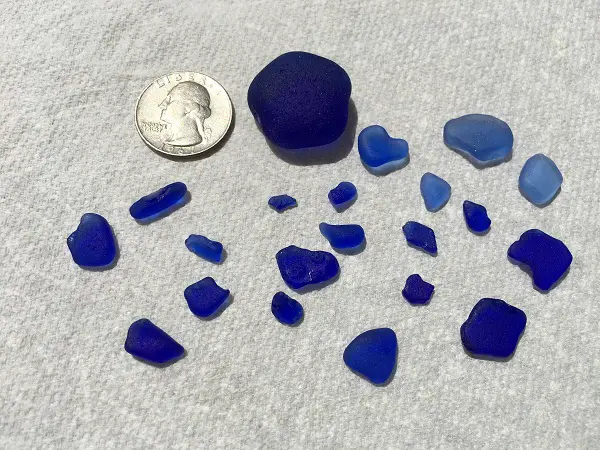 various sizes and colors of dark blue sea glass